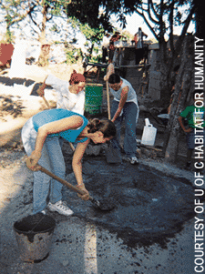 image: Student volunteers mix concrete to support beams of a Nicaraguan house.