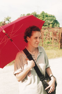 IMAGE:  Rachel Cole, an umbrella as her sunblock, in a Dominican batey. 