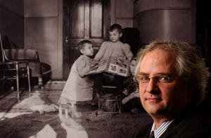 PHOTO:  Chapin Hall Center for Children director Mark Courtney stands before a turn-of-the-century photo of orphans cared for in one of the center’s earliest incarnations.