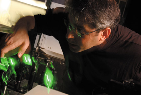 IMAGE:  Physics professor David Grier adjusts the projector used to create holographic optical tweezers. The green lights are lasers.