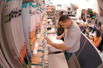 image:  Admissions staff members Nenora Anderson and Christopher Shorter sort through College applications.