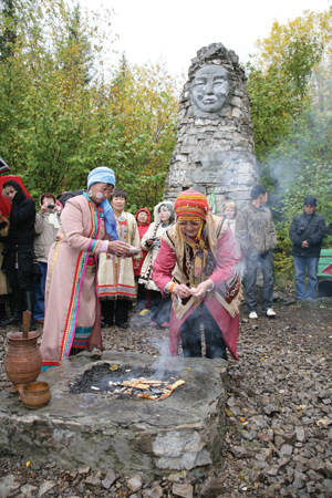 An Even elder feeds a ceremonial fire.