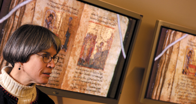 IMAGE:  Margaret M. Mitchell, AM’82, PhD’89, shows off Archaic Mark on one of Special Collections’ 50-inch plasma screens.