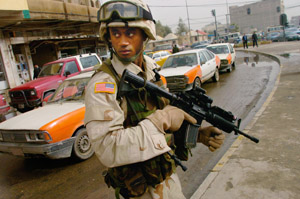 image:  A 101st Airborne Division sergeant watches his back while patrolling a Mosul marketplace.