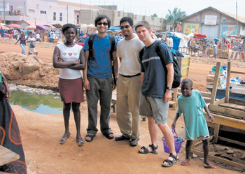 photo: Flanked by two Ghanese kids who wanted their photos taken are Harish Amirthalingam, ‘05, Dutta-Gupta (center), and Clay Collins, a University of Minnesota doctoral student.